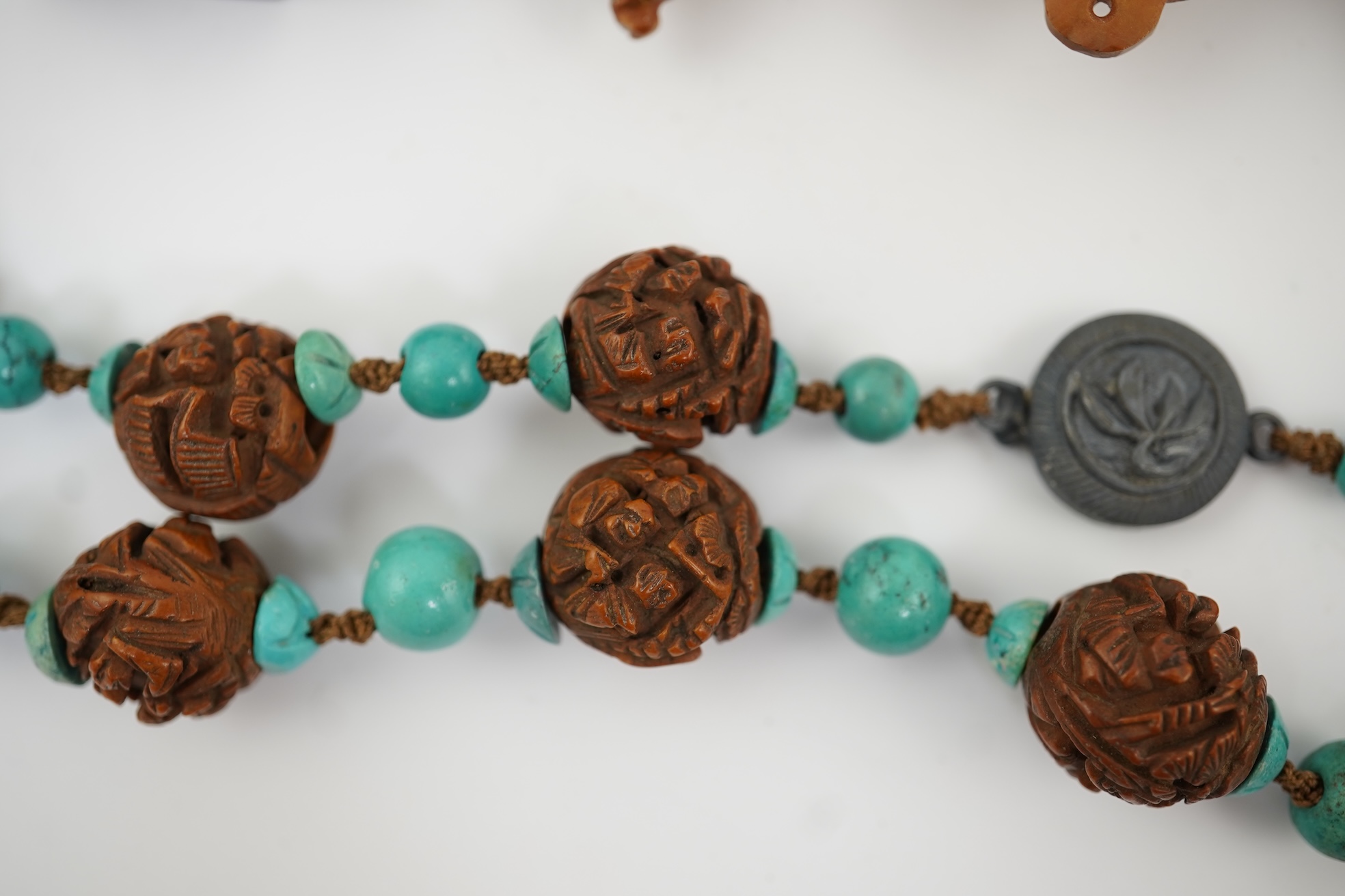 A Chinese silver filigree work and enamel scent bottle, by Wongshing, three carved peach stones, and a kernel and turquoise bead necklace, late 19/early 20th century